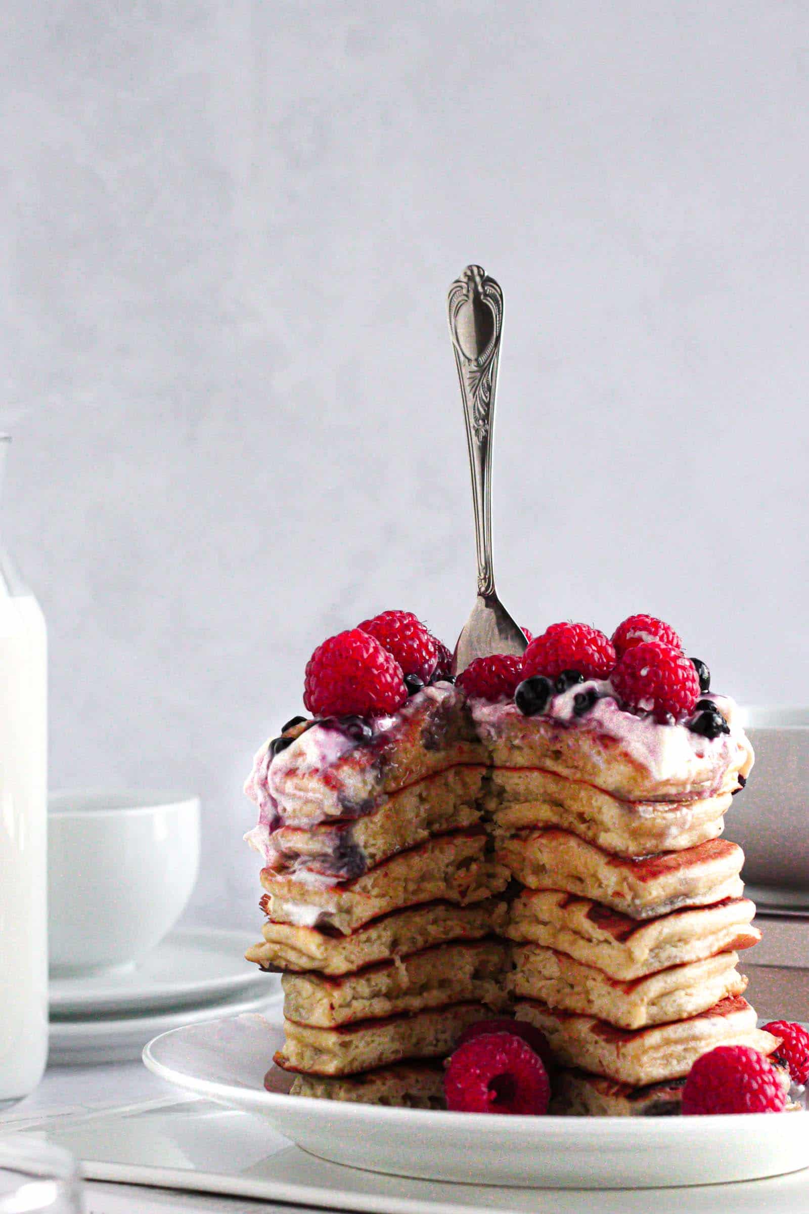 Pancakes thick and fluffy topped with fruits, yogurt and maple syrup