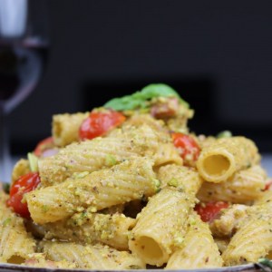 Tortiglioni with Pesto Pasta. Pesto made of fresh basil, pistachio, parmesan, accompanied by cherry tomatoes and pancetta.