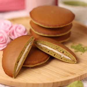 matcha dorayaki japanese pancakes with white chocolate on a wooden plate.