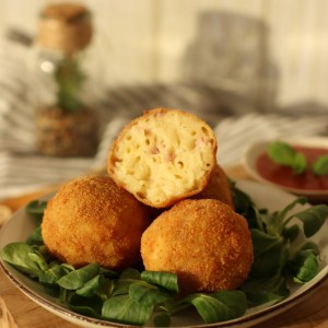 macaroni croquettes balls with ham and cheese mixed with pasta rolled into a ball then fried.