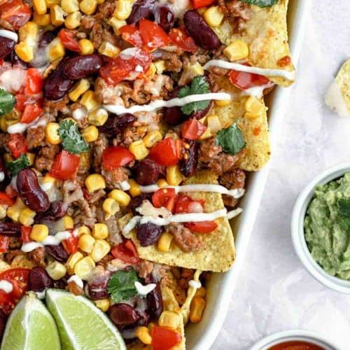 crispy tortilla chips, layer seasoned beef, juicy tomatoes, beans, corn, melted cheese and serve with some sour cream, spicy salsa sauce, and a creamy guacamole.