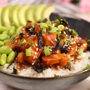 The marinated salmon is coated with an incredibly delicious homemade teriyaki sauce and served on top of white rice with avocado and edamame.