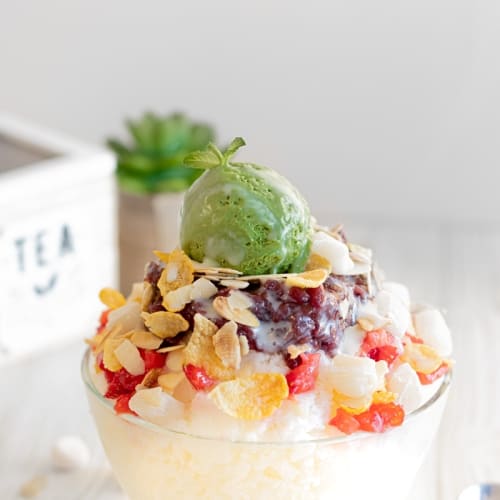 Patbingsu milky shaved ice topped up by sweet red beans, corn flakes, chewy mini rice cakes, roasted shaved almonds, strawberries, a drizzle of condensed milk and some incredible creamy homemade matcha ice cream.