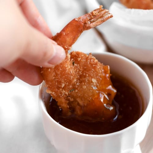 shrimps coated with panko breadcrumbs and shredded coconut, fried and served with a sauce made of apricot jam and chilli sauce.
