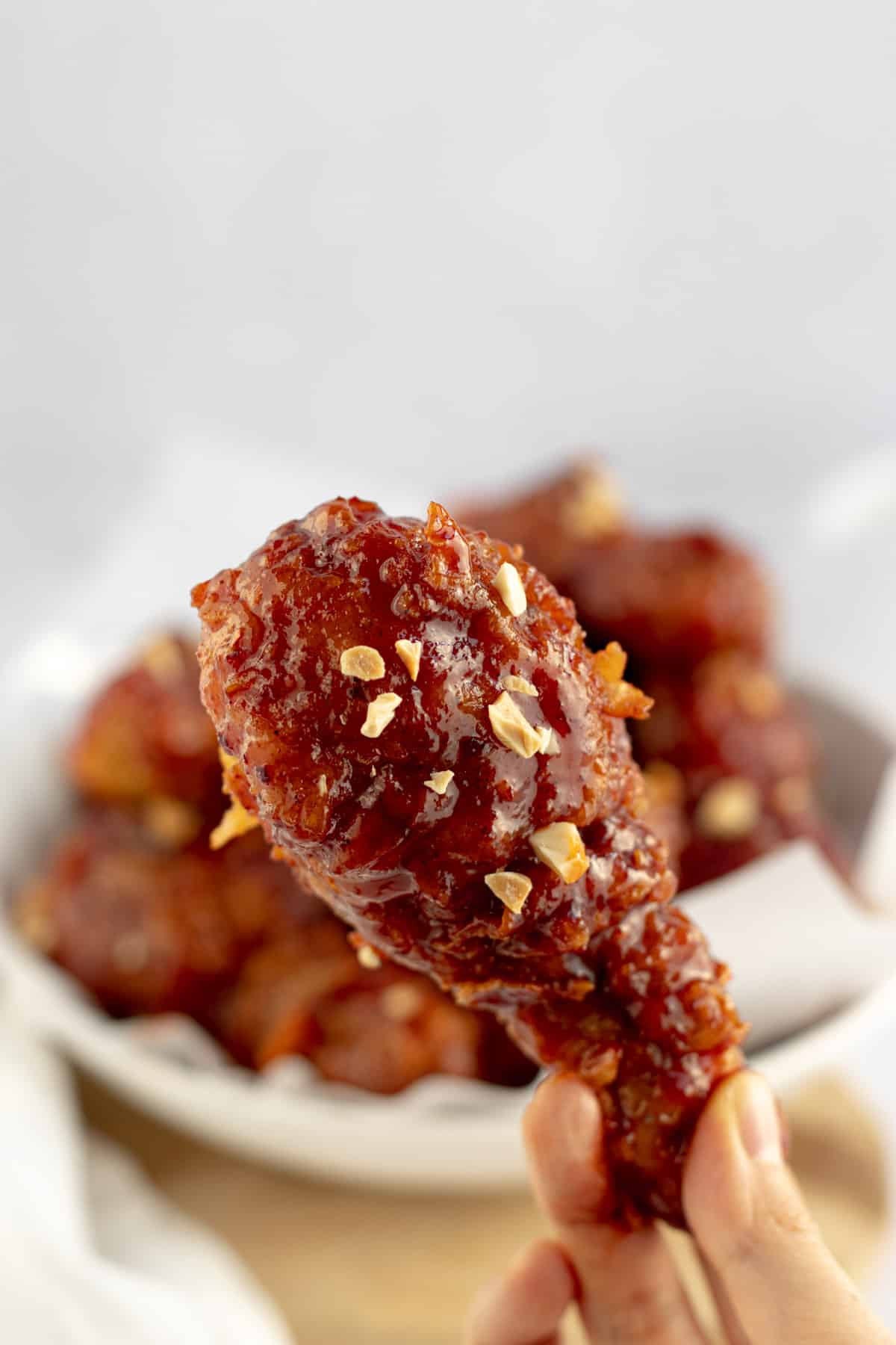 spicy korean fried chicken dakgangjeong chicken drumsticks covered with a sweet and spicy sauce sprinkled with peanuts