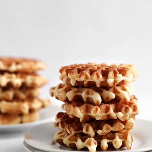 4x4 belgian waffles piled up on a plate.