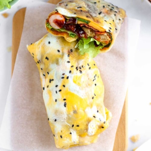 a Chinese crepe for breakfast (jianbing) made with a batter topped with an egg then filled with bacon, cheese and wonton cracker.