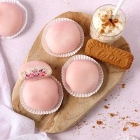 pink mochis filled with strawberry cheesecake on a wooden board