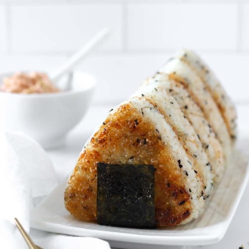 5 tuna kimchi yaki onigiri aligned on a white plate.