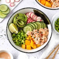 a poke bowl with rice, spicy salmon and other healthy toppings