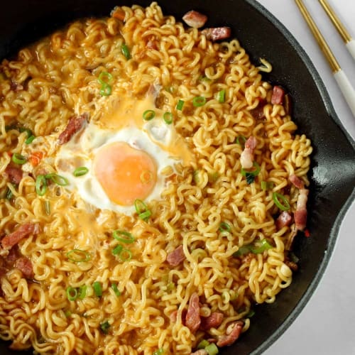shin ramyun in a pan with an egg in the middle.