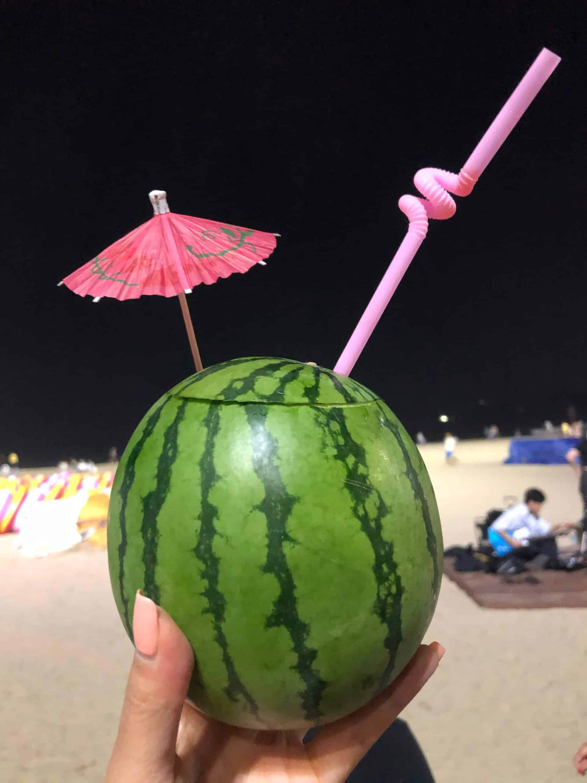watermelon juice served in a watermelon with a beach background in Haeundae, Busan.
