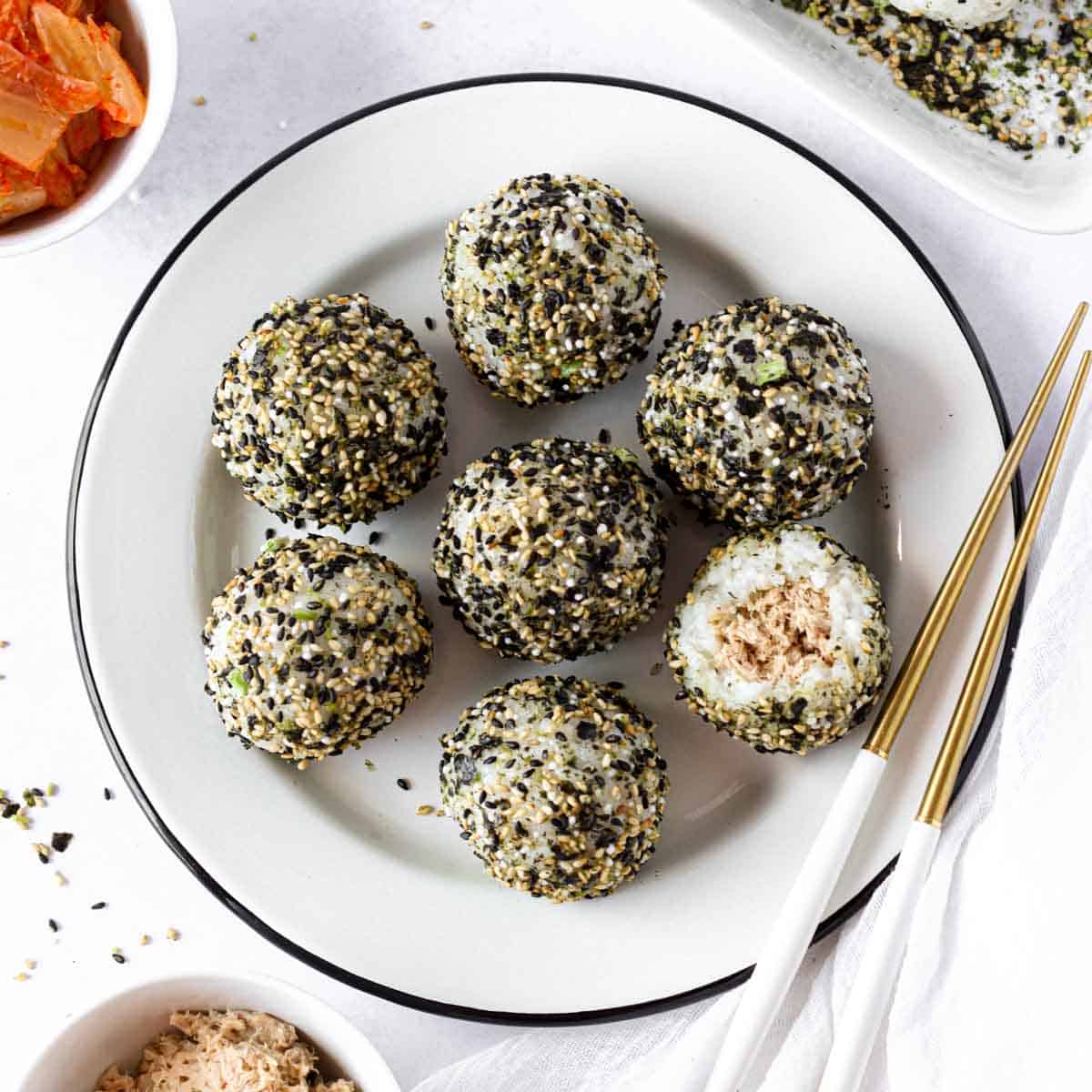korean rice balls with tuna mayo on a white plate with kimchi as a side dish