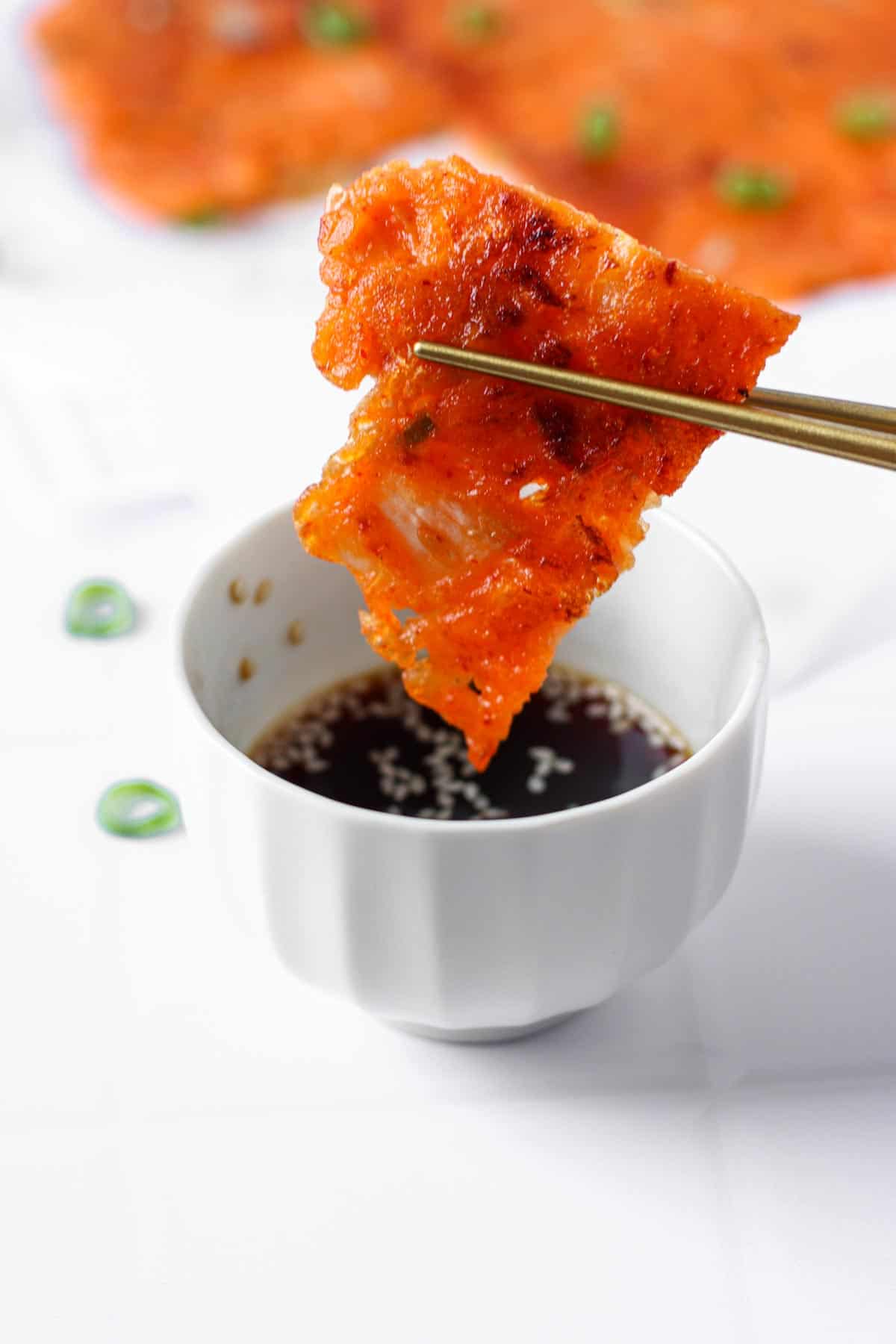 kimchi pancake dipped in sauce.