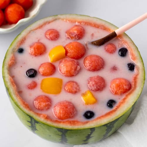 watermelon hwachae featuring watermelon balls, canned peaches and blueberries.